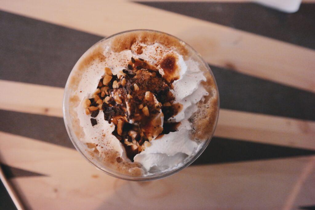 Top view of a creamy coffee with hazelnuts, perfect for dessert lovers.